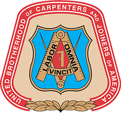 Shield-shaped emblem with a blue background, golden compass and square, and Latin motto “Labor Omnia Vincit.”
